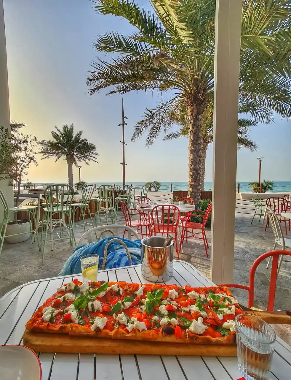 Pizza served at beach restaurant with palm trees