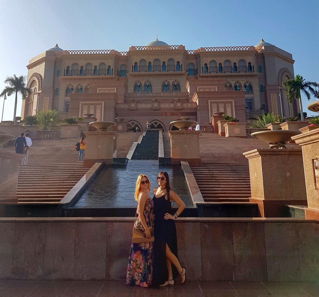 Two women standing in front of the opulent Emirates Palace hotel