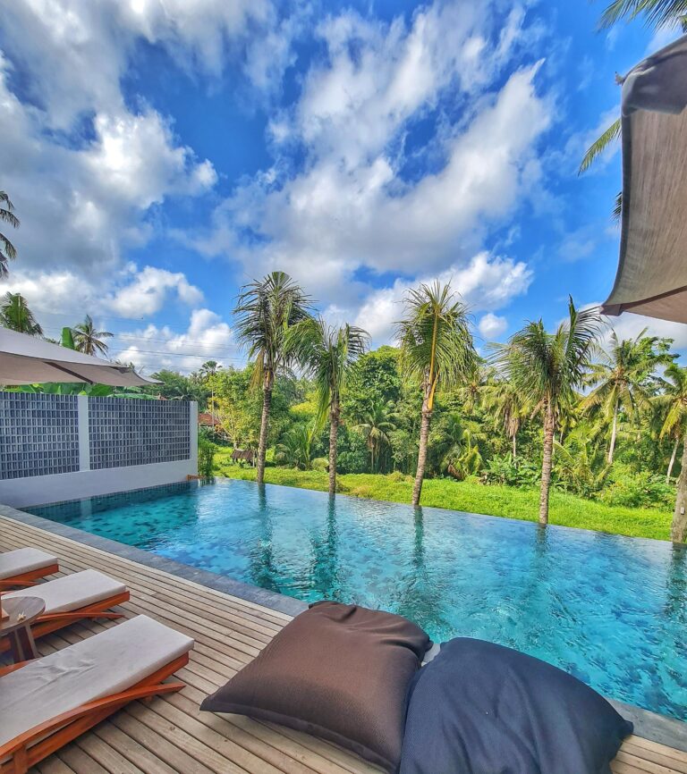 Infinity pool in Bali with palm trees and a beautiful tropical setting on a sunny day