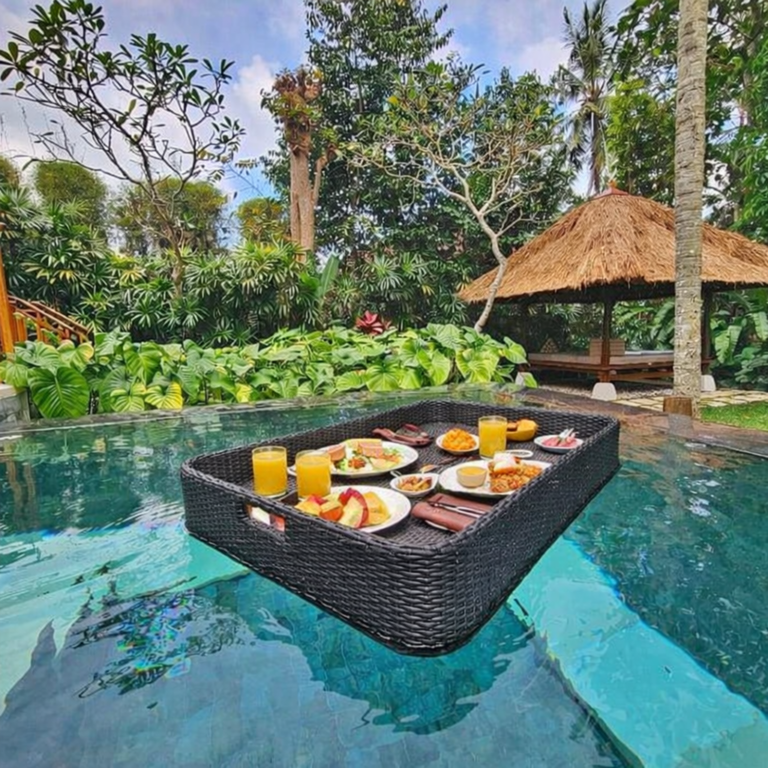 Floating breakfast served in a pool at a luxury hotel in Bali with tropical surroundings