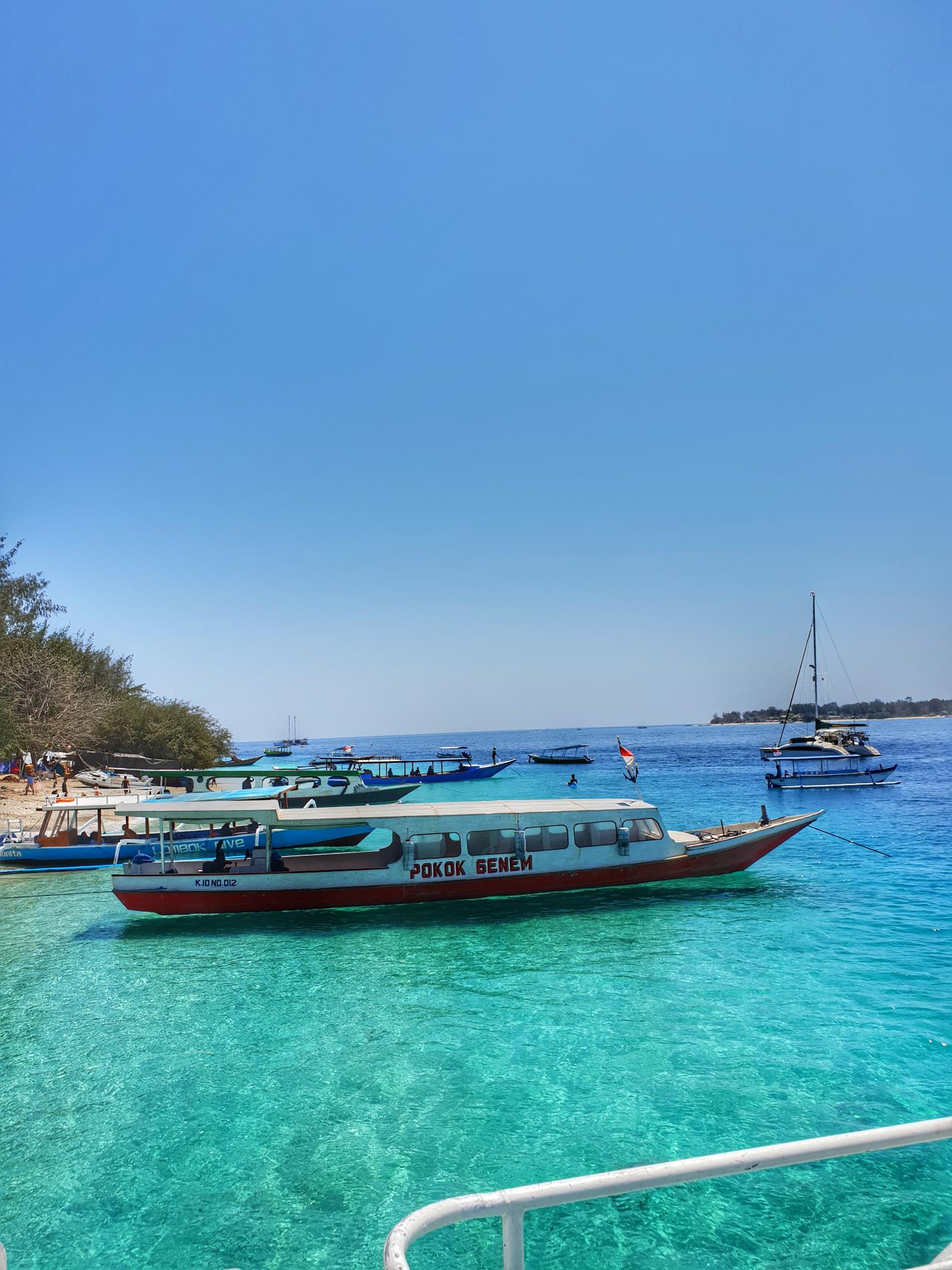 Boats on crystal clear sea with calm tropical scenery