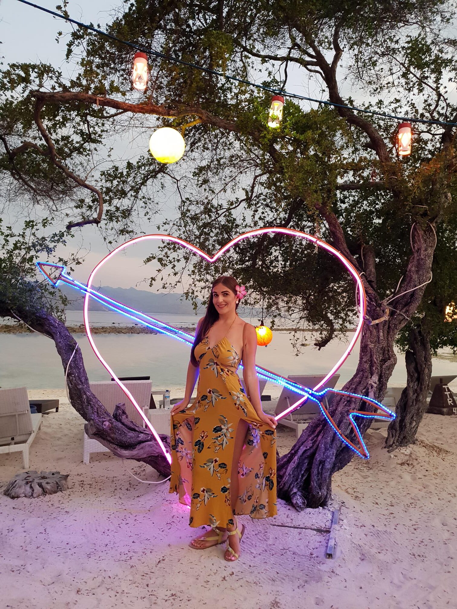 Woman in a flowing dress on Gili Trawangan beach with turquoise sea and tropical vibes.