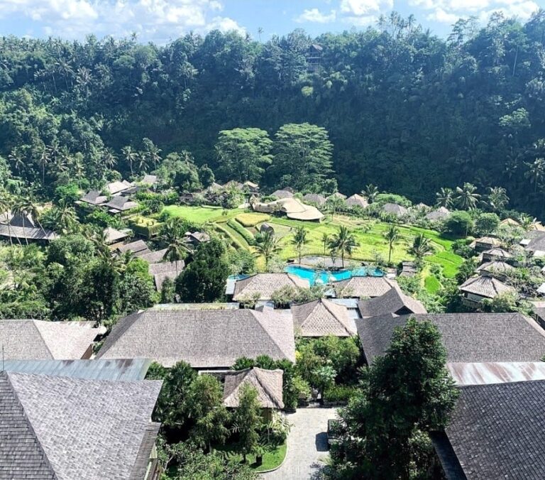 View from a balcony overlooking a resort pool with tropical greenery and nearby villas at Mandapa, a Ritz Carlton Reserve