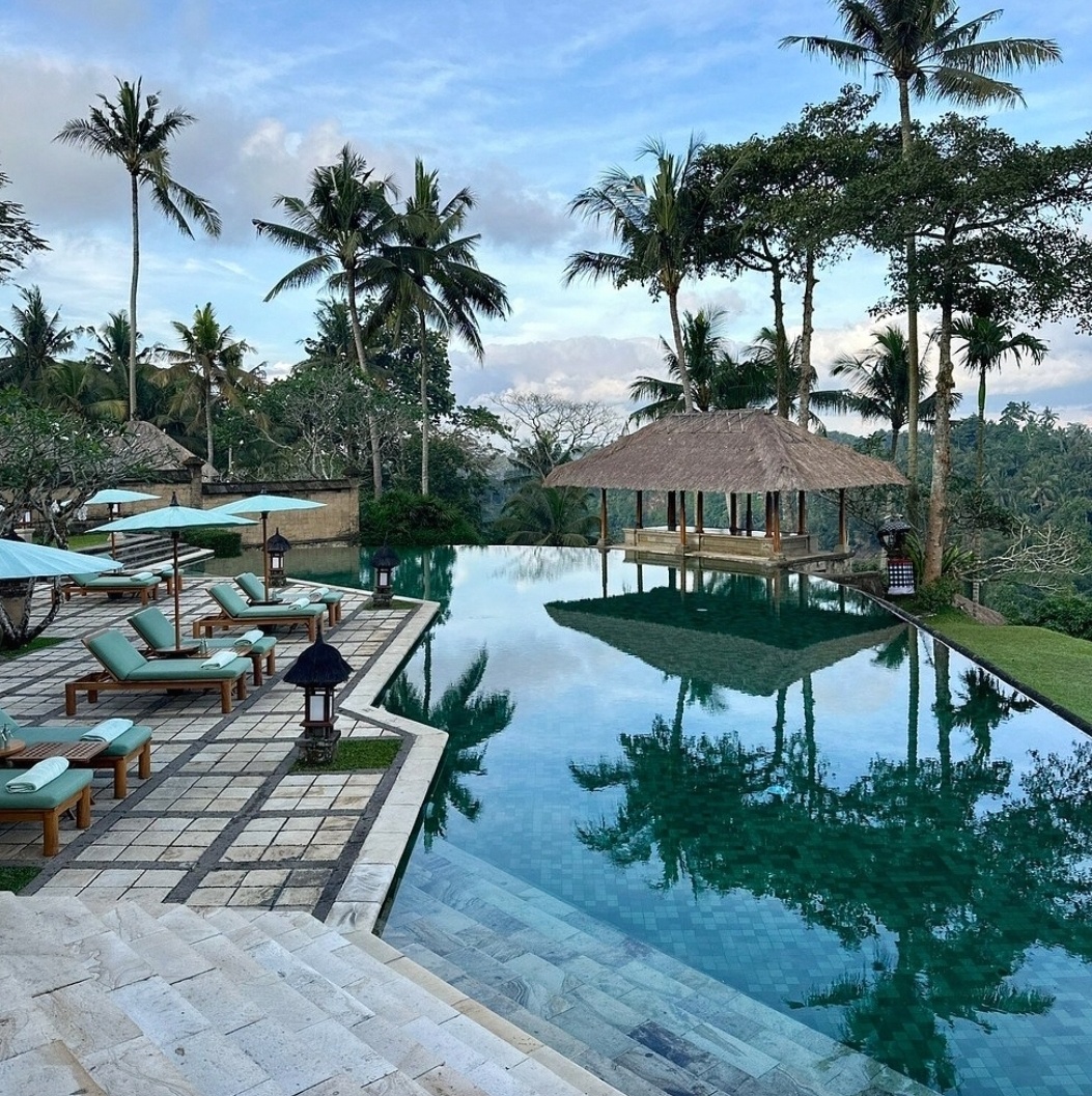 Elegant resort pool in Bali with lush tropical greenery in the background