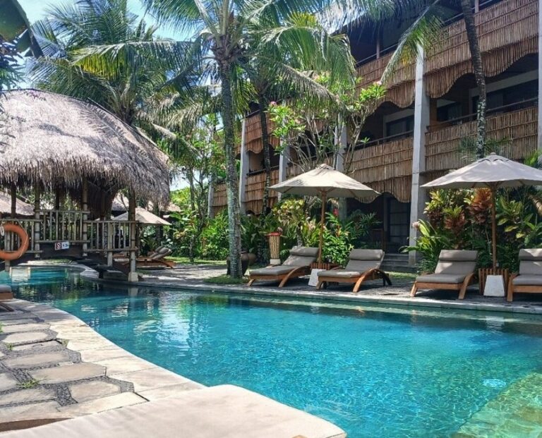 Pool with chairs and villa/restaurant in background: