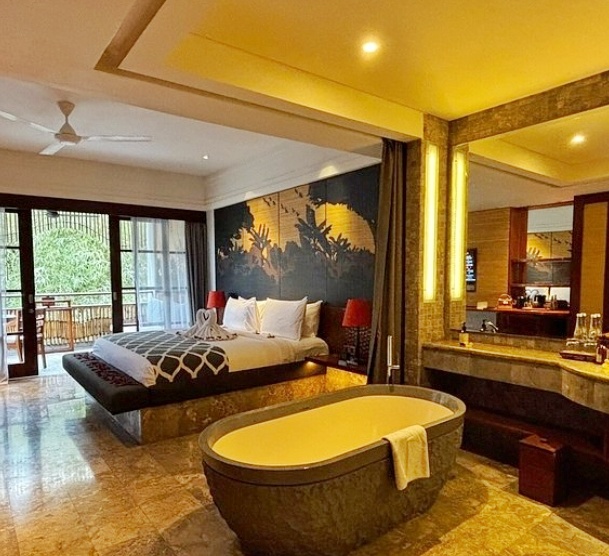 Luxury hotel room in Bali with an integrated bathroom and jacuzzi, featuring an open layout and scenic view