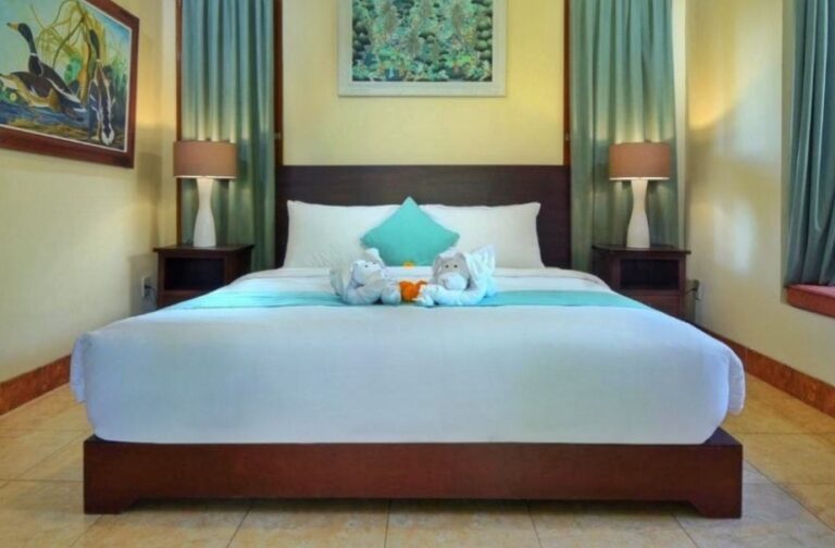 Simple hotel room in Bali with a neatly arranged bed and bedside lamps