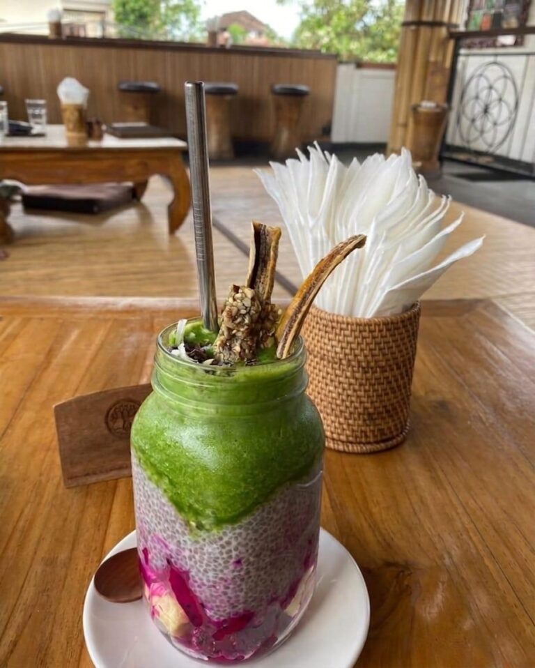 Healthy smoothie on a table at Seeds of Life in a bright tropical setting with greenery
