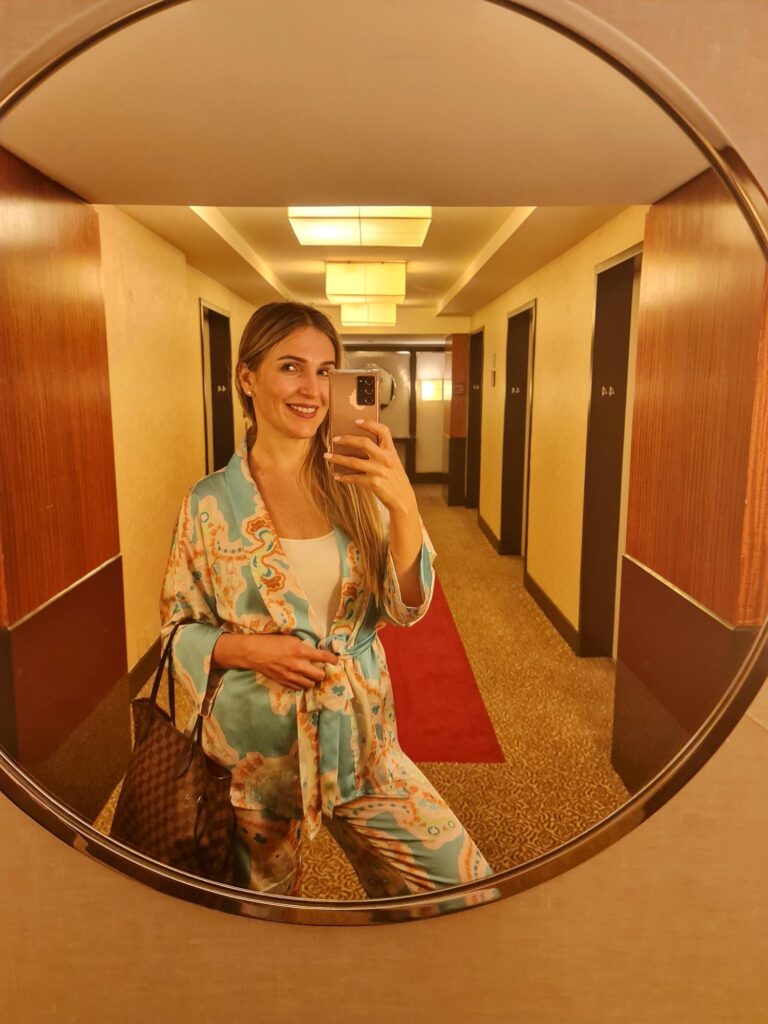 Woman taking a mirror photo in a hotel corridor in New York City