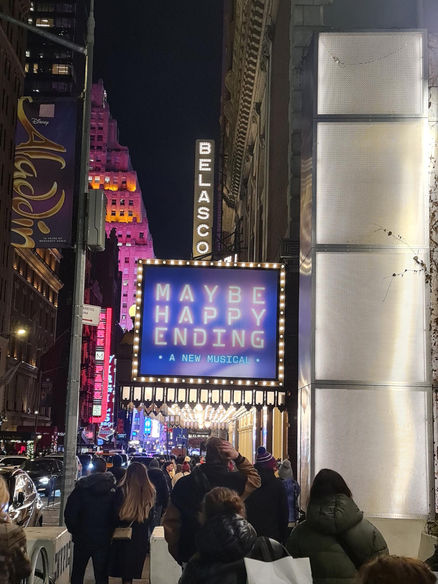 Crowded Times Square area near Broadway theaters with glowing advertisements and lights