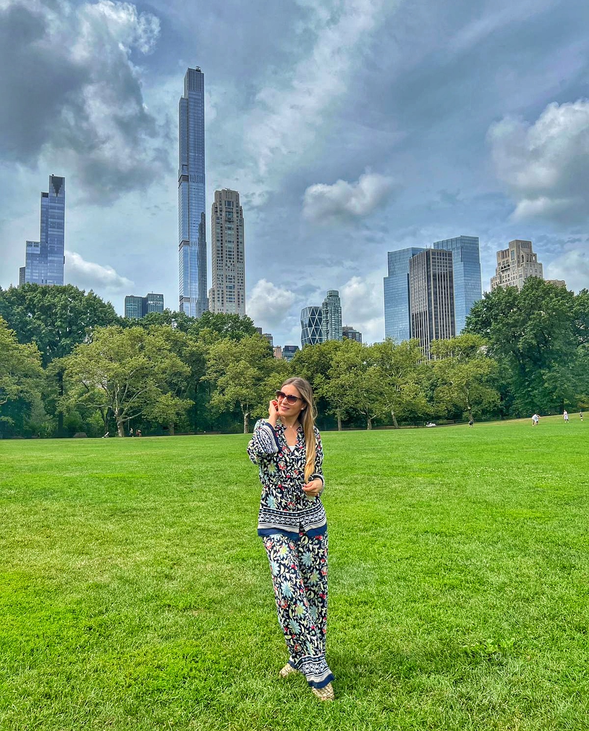 Standing in Central Park with Manhattan skyline views in New York City.