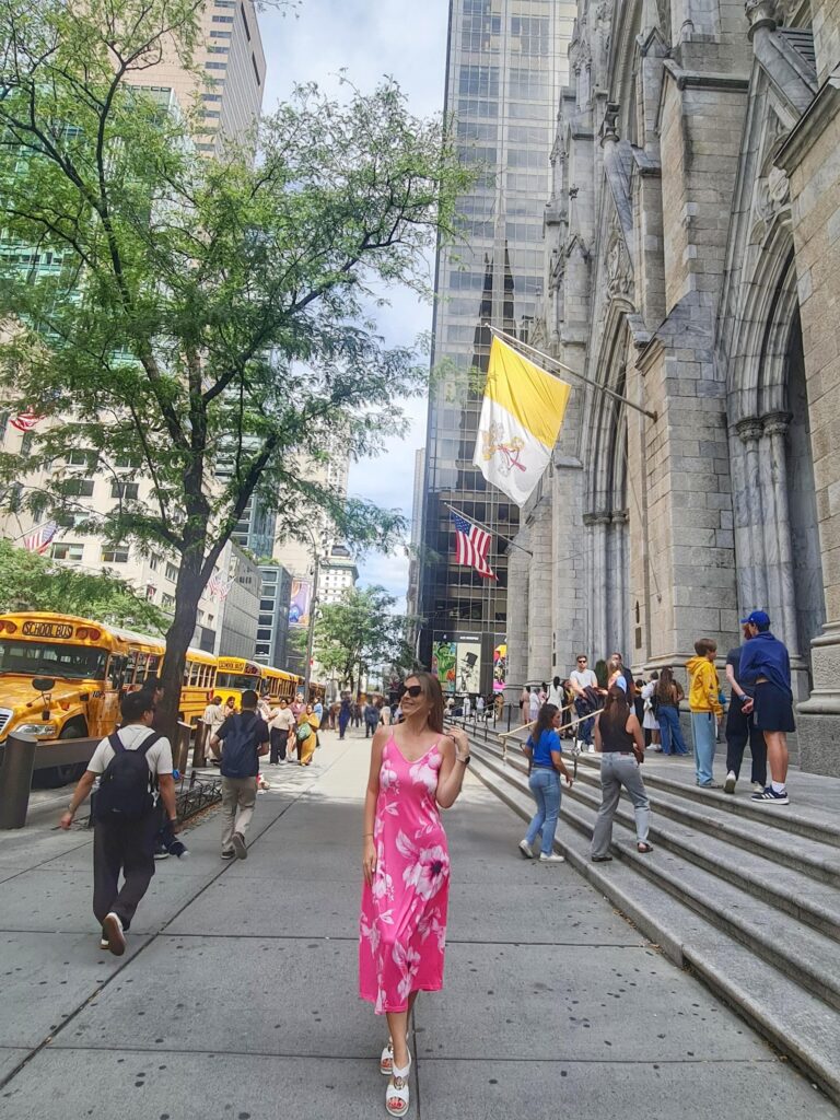 Woman in a pink dress standing in front of St. Patrick’s Cathedral on Fifth Avenue in New York