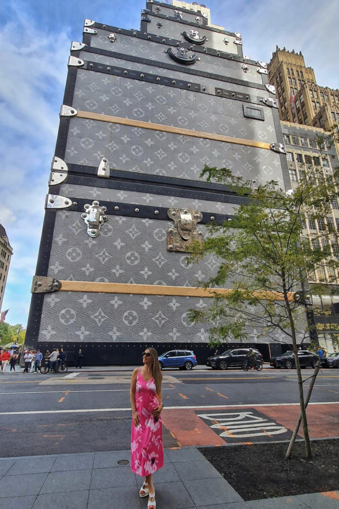 Woman standing in front of Louis Vuitton building on Fifth Avenue NYC