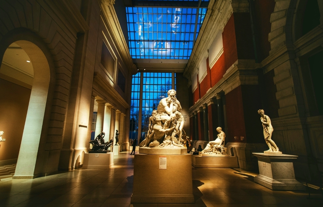 Art gallery inside the Metropolitan Museum of Art with historical artworks displayed along the walls