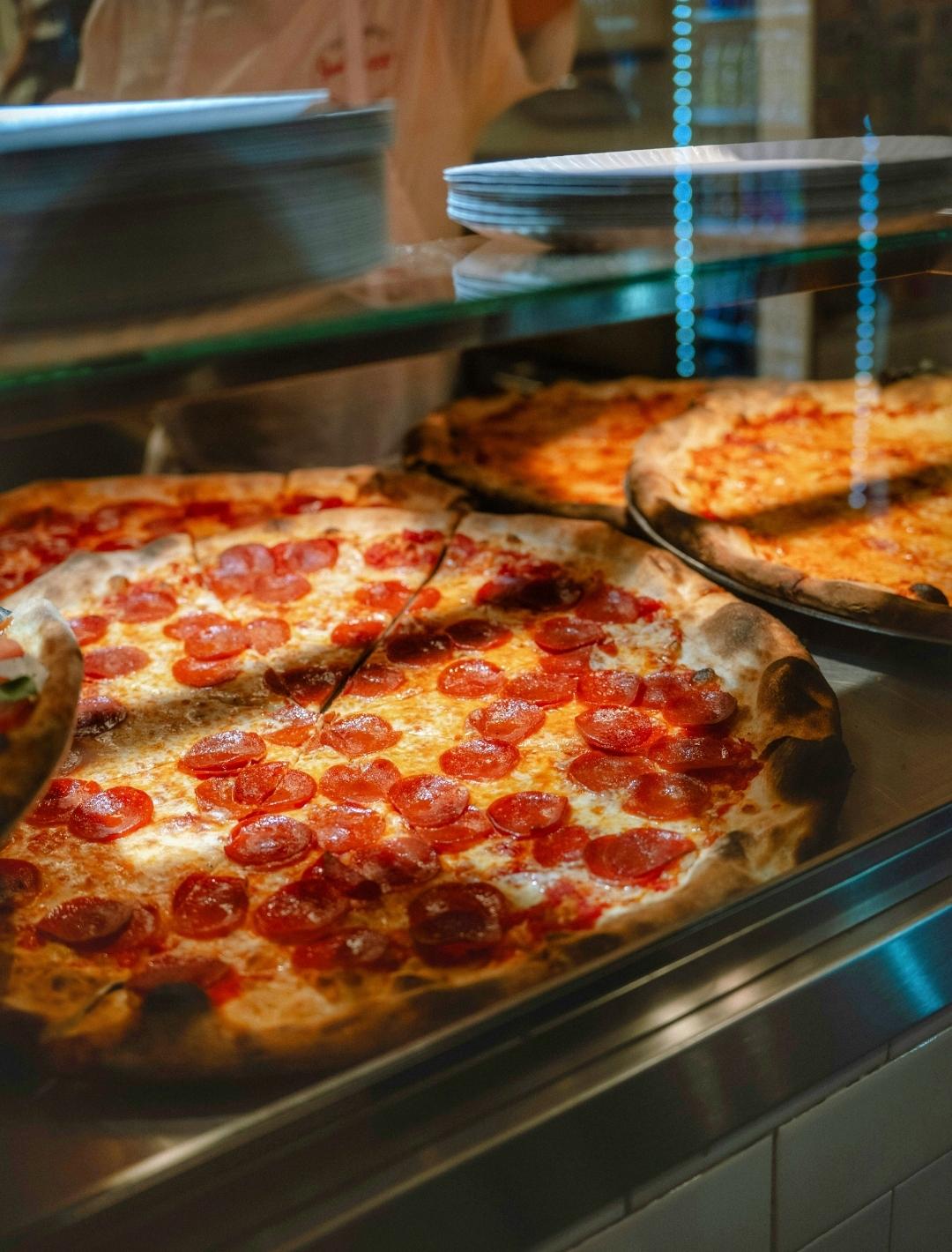 New York-style pizza slice with thin crust and melted cheese, iconic NYC street food