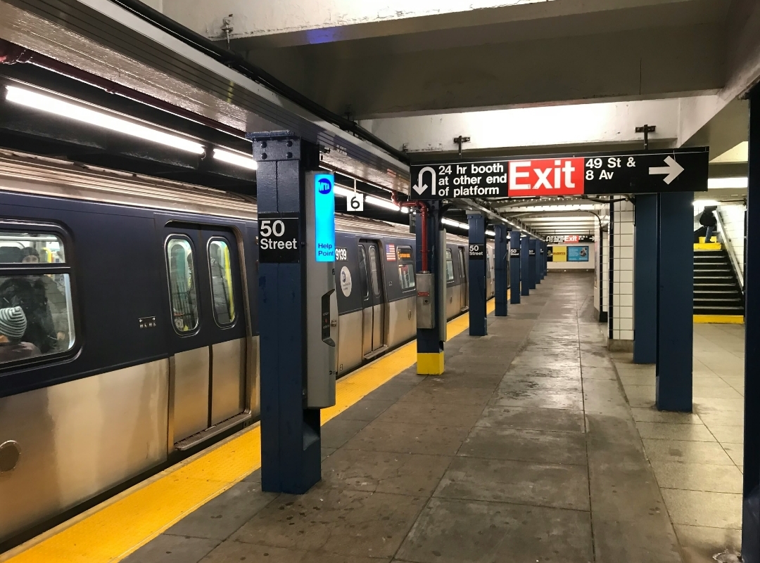 Interior of NYC subway tunnel with train arriving at the station in Manhattan