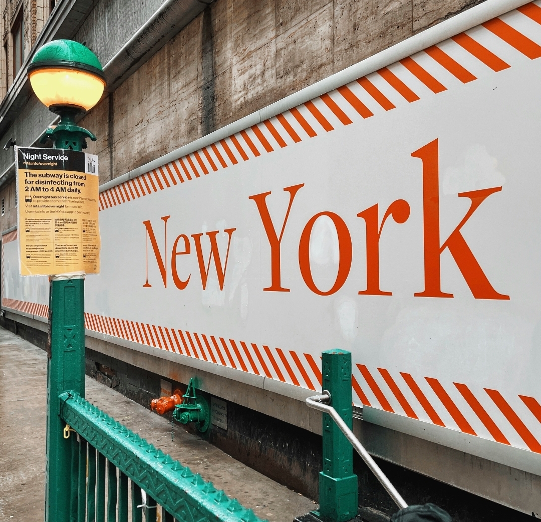 New York City subway station underground platform with trains and commuters