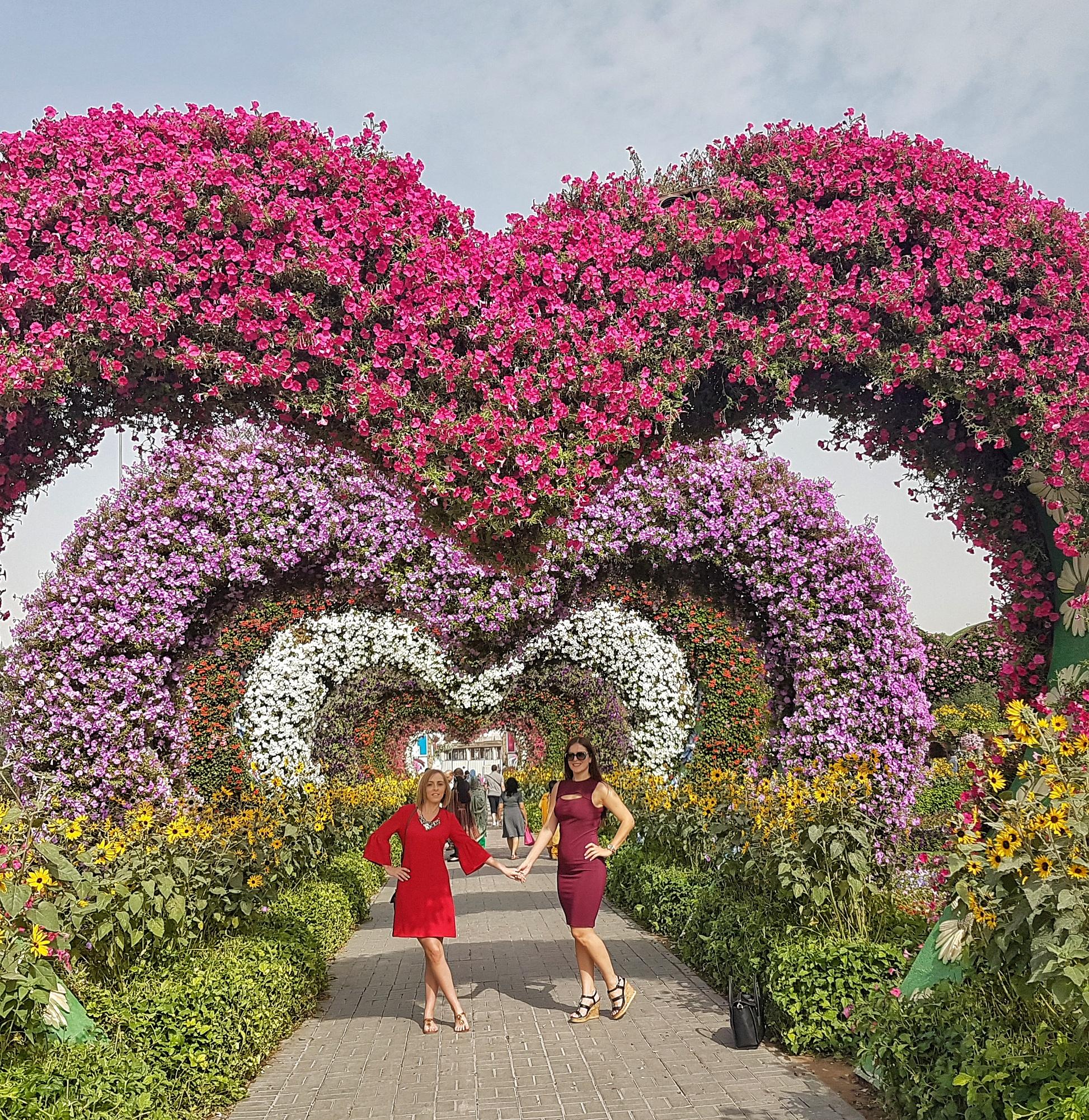 Visitors walking through Dubai Miracle Garden surrounded by colorful flowers