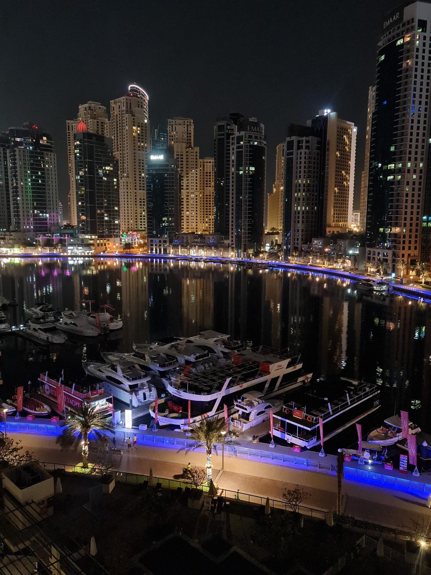 Dubai Marina night skyline view with yachts, water, and city lights from a hotel