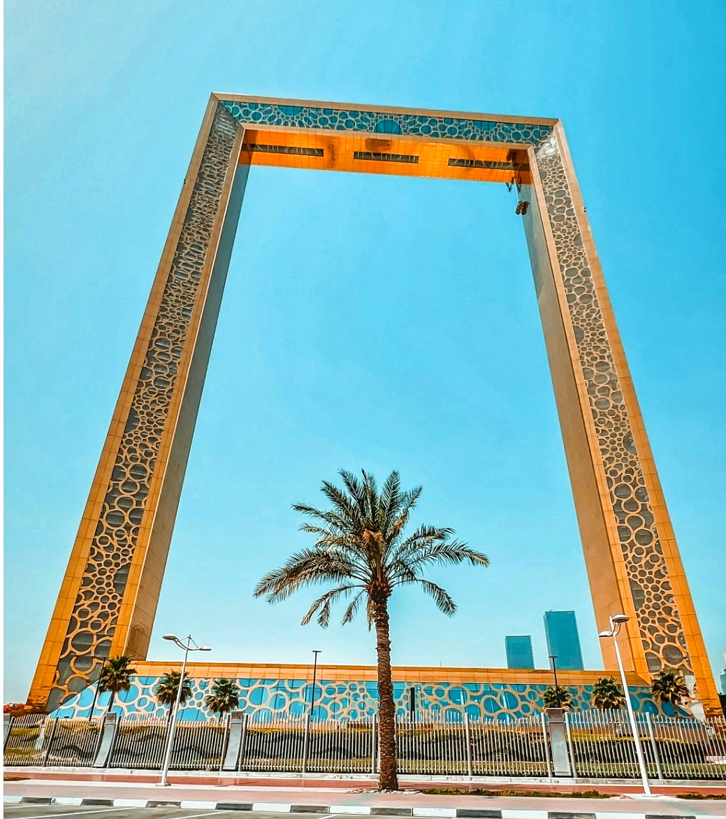 Exterior view of Dubai Frame with a palm tree in front